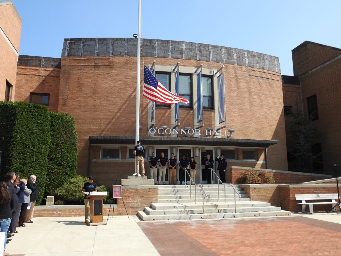 People saluting the American flag outside of O'Connor Hall.