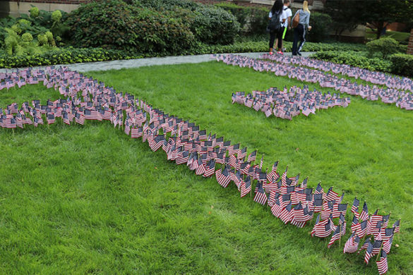 Small flags arranged into 9-11 on the grass.