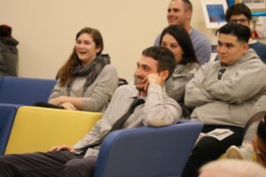 Students seated and smiling.