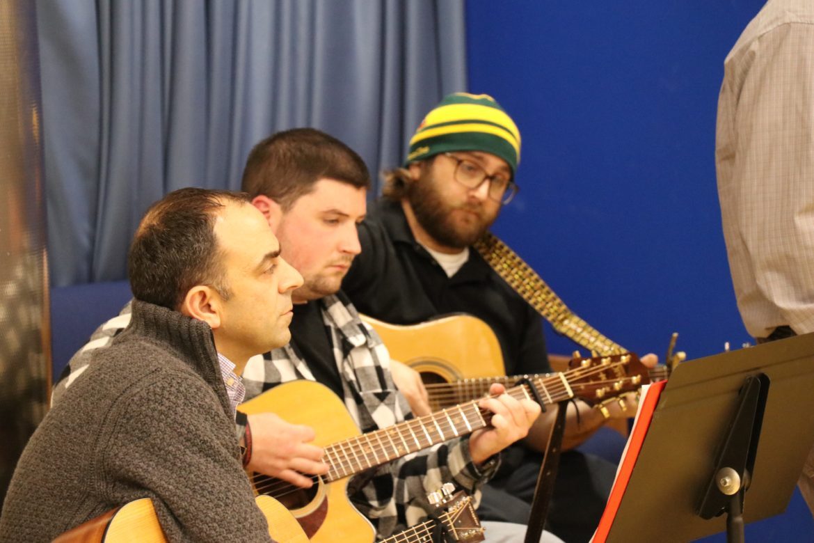 Musicians seated and singing.