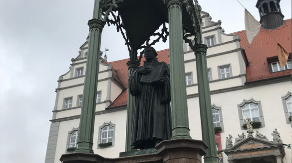 Statue of a man holding a book.