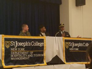 Three men seated on stage discussing airline industry.