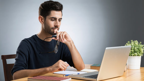 Male student studying at a laptop.