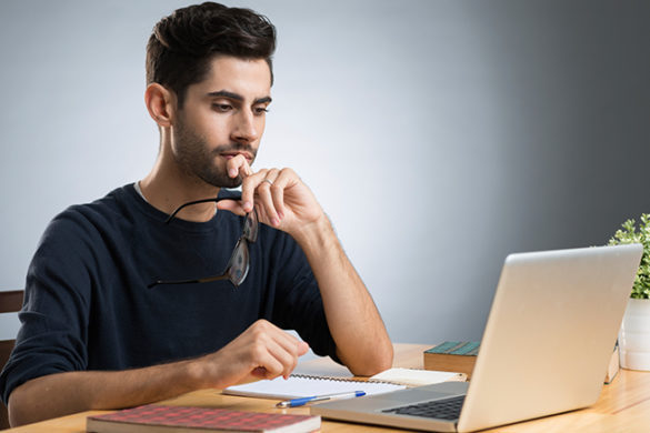 Male student studying at a laptop.