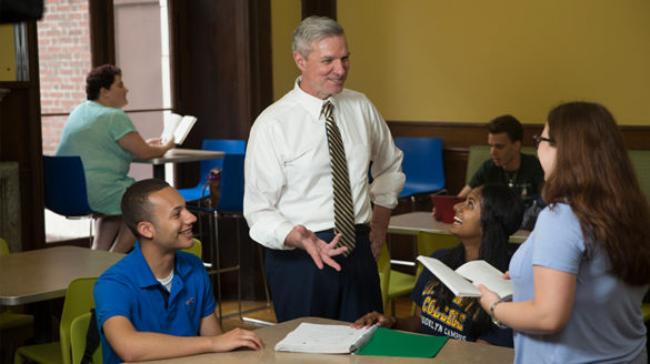 Administrator and college students talking.