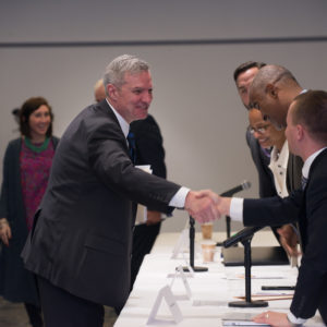 College president shaking hands with other educators.