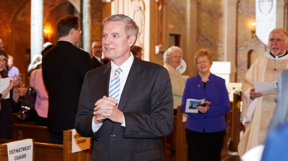 College president walking up church aisle.