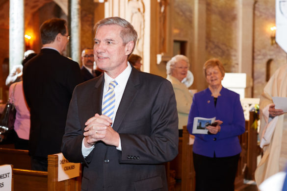 College president walking up church aisle.