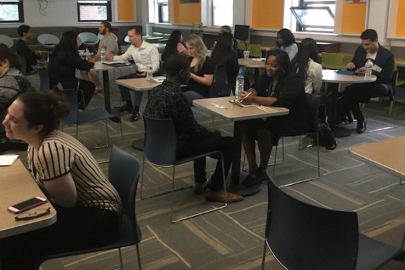 Adults and students seated across from each other.