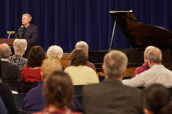 Man at podium speaking to audience.