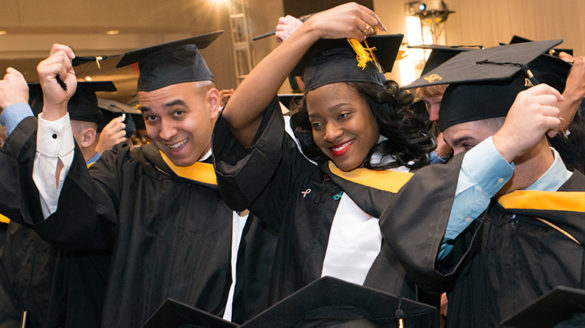 Graduates with caps and gowns on.