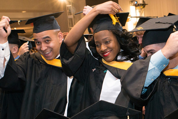 Graduates with caps and gowns on.