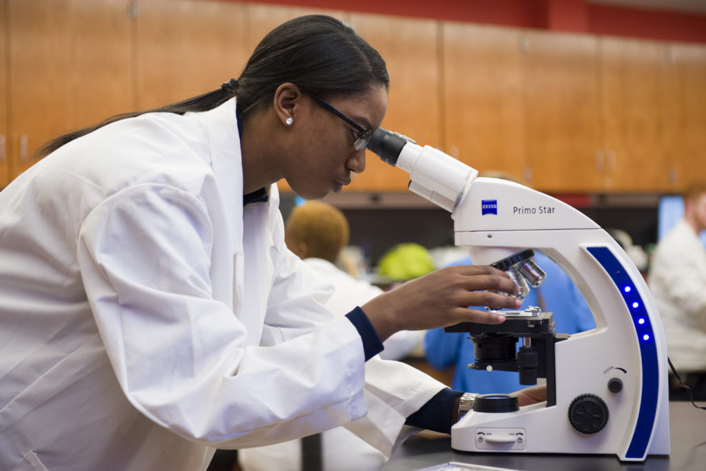 Student using microscope at SJC.