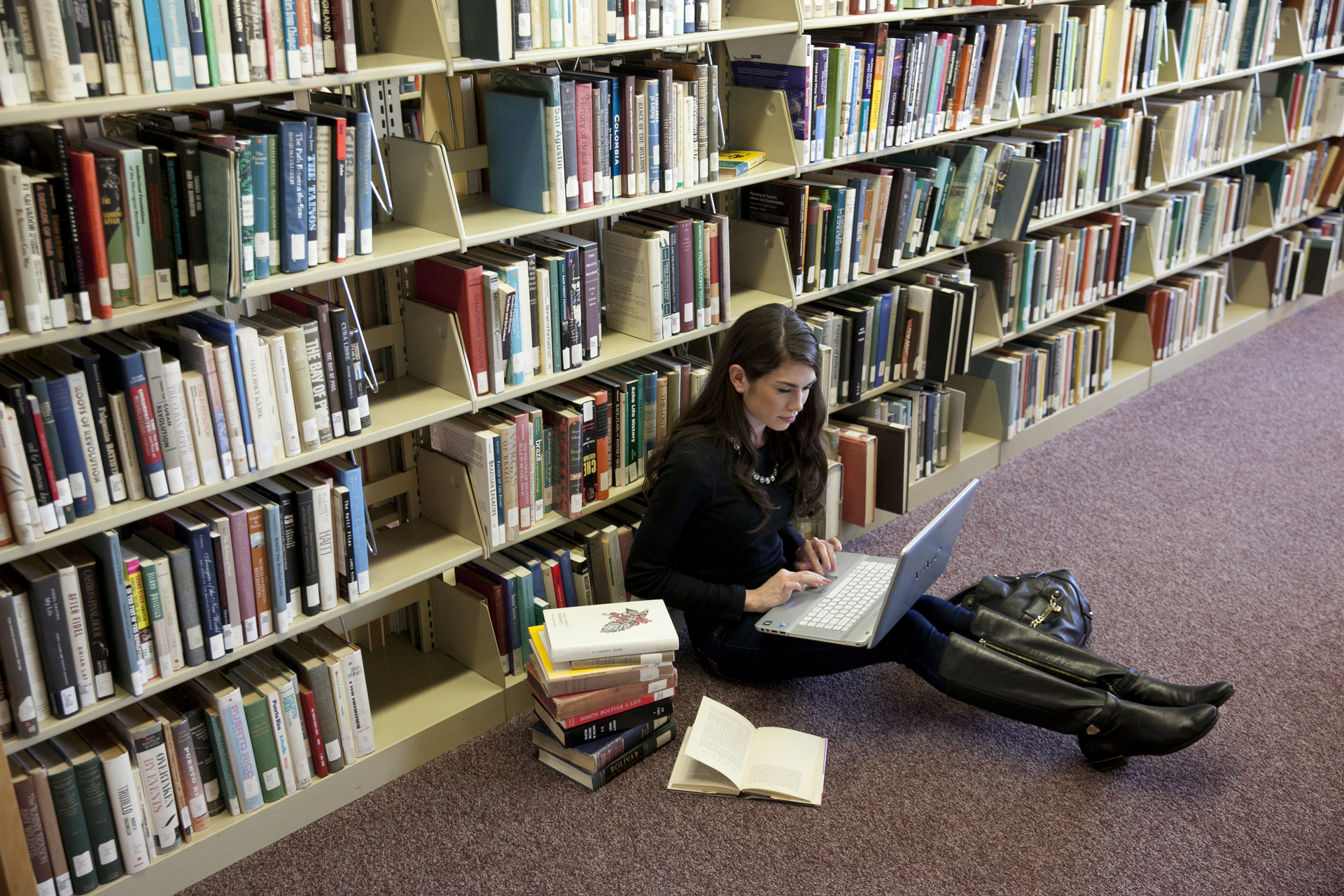 Student on laptop in SJC Long Island's Callahan Library. 