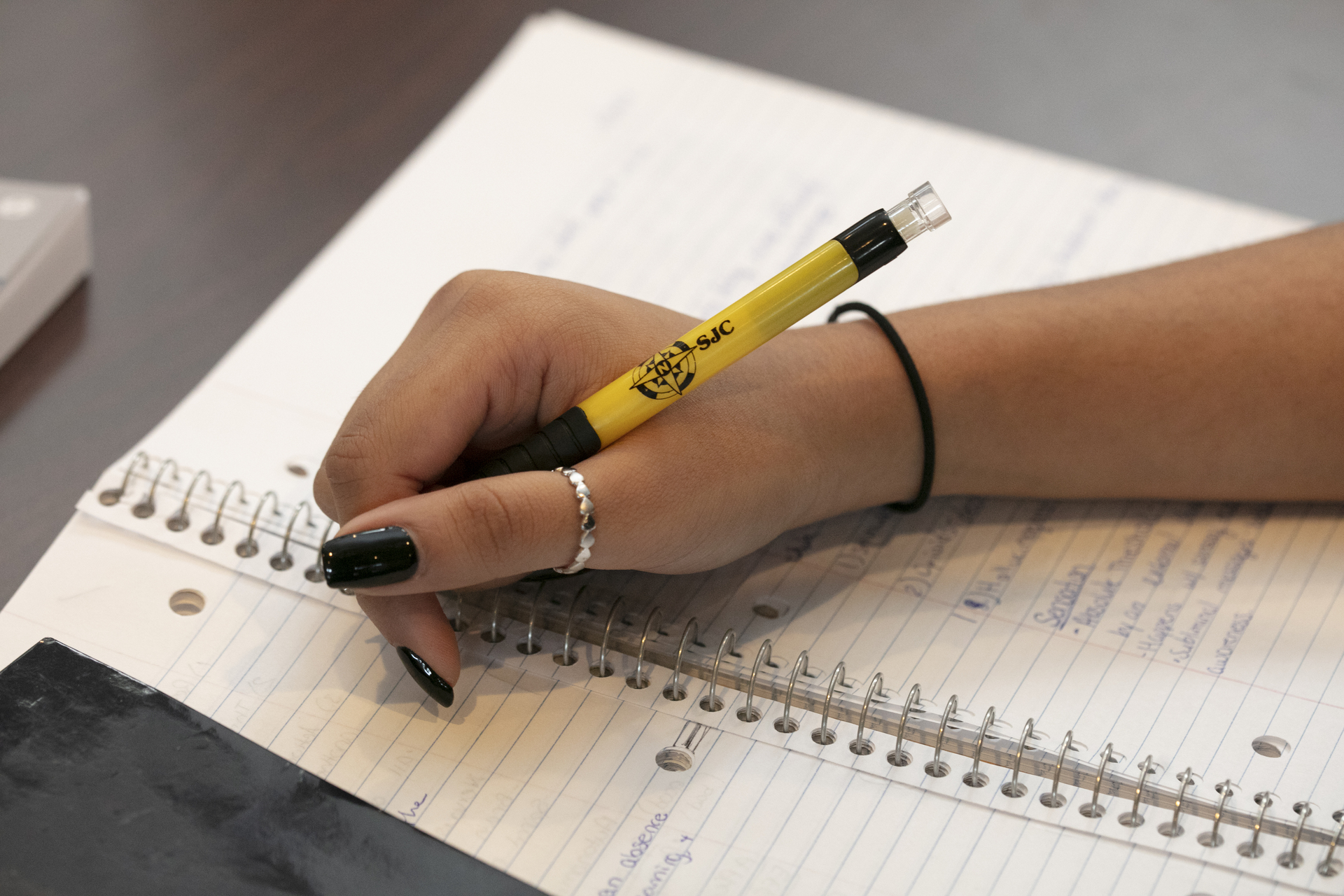 Student writing in notebook.