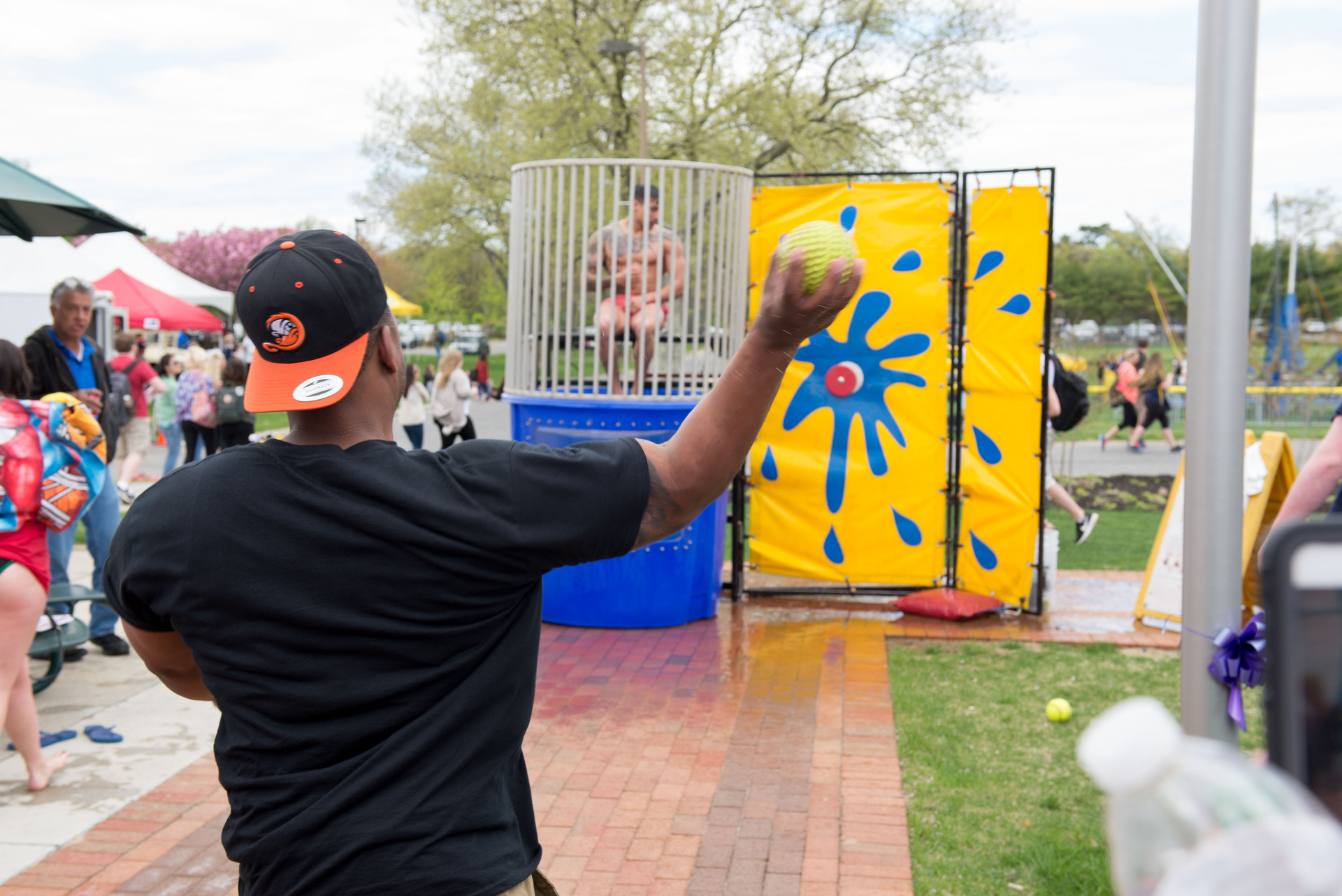 Student throwing ball at dunk tank.