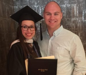 Two adults standing at graduation event.