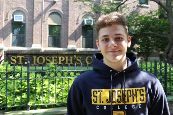 Student in front of St. Joseph's sign.