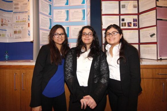 Three students at past event, standing.