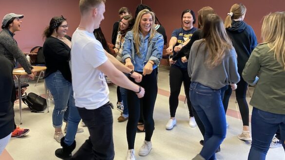 Students laughing and moving about the classroom.