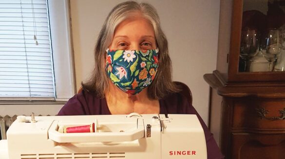 Woman sewing and wearing a mask.