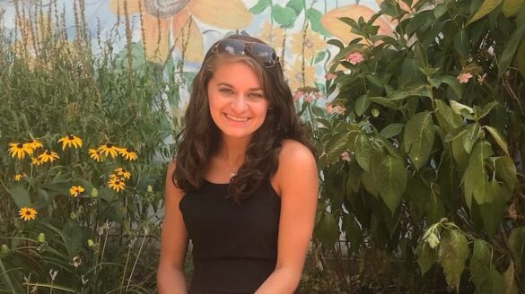 A young woman seated and smiling.