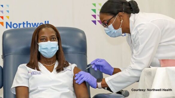 Nurse receiving vaccine shot.