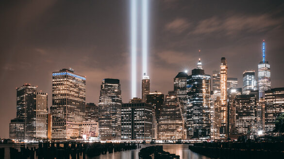 A night view of New York City, with two lazer lights where the twin towers used to sit.