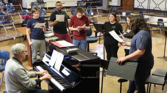 Students singing with professor